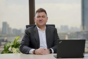 Confident middle-aged businessman in an elegant office with city view.